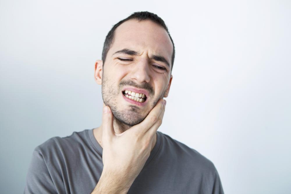 Man holding face in pain from periodontal disease near Chico CA